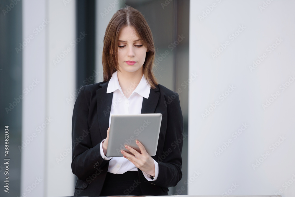 Portrait of a businesswoman taking notes on an electronic tablet, on the street Portrait of a businesswoman taking notes on an electronic tablet, on the street