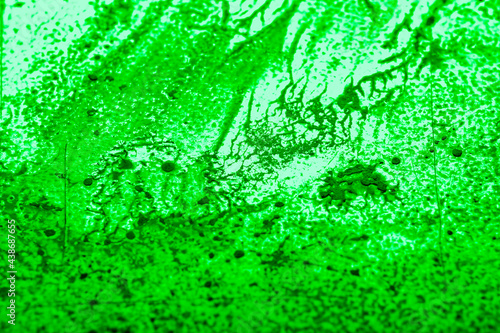 Paint spilled and smeared over a textured plastic surface. Light overlay pattern with dried paint texture. Blurred image at an angle