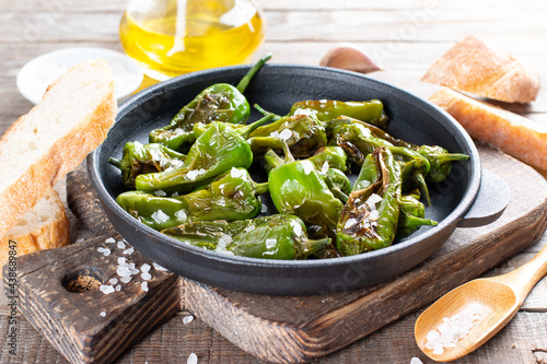 Authentic Spanish padron peppers with salt and olive oil on frying pan on a table photo