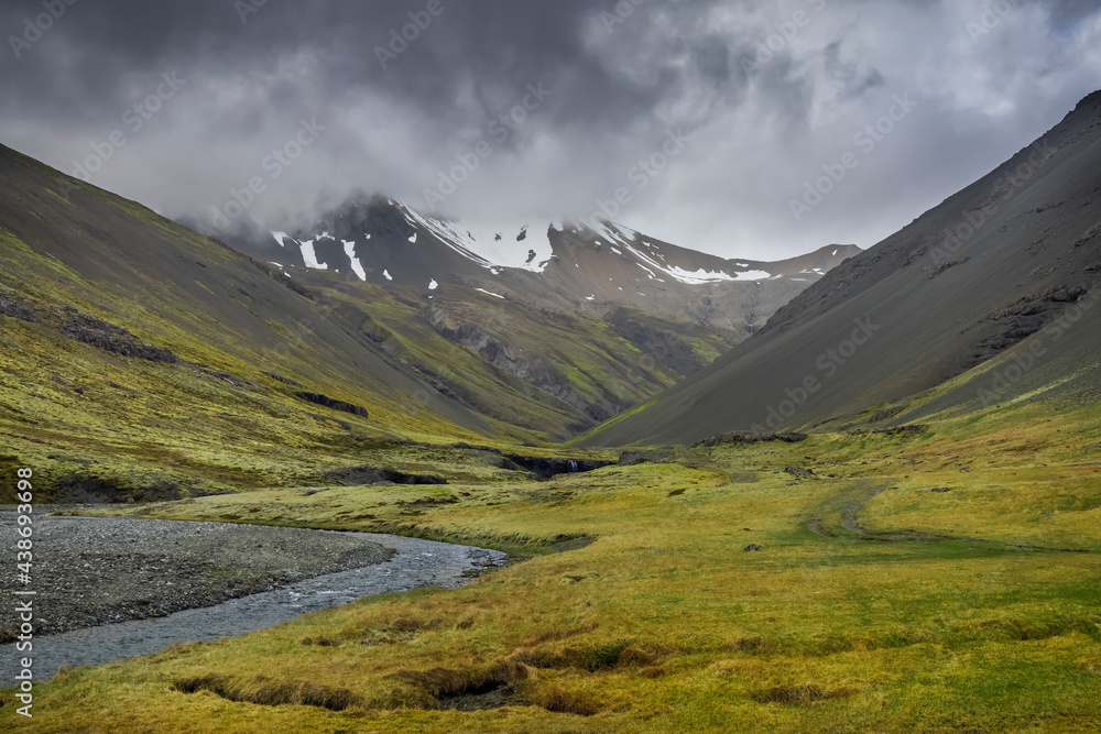 Icelandic mountain scape with dark cloud cover near Skutafoss