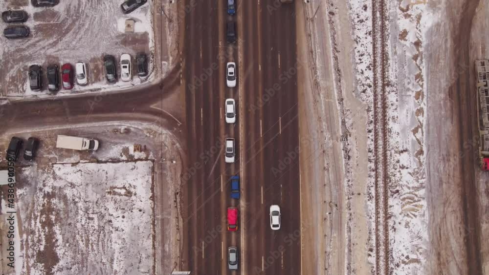 Aerial top view of crossroad intersection with busy urban traffic at winter time with snowfall Aerial top view of crossroad intersection with busy urban traffic at winter time with snowfall