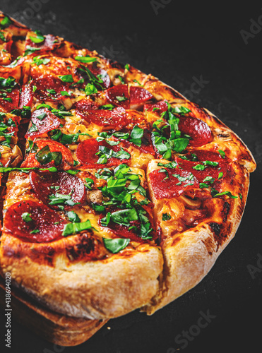 Pepperoni Pizza with Mozzarella cheese, salami, Tomato sauce, pepper, Spices. Italian pizza on Dark grey black slate background