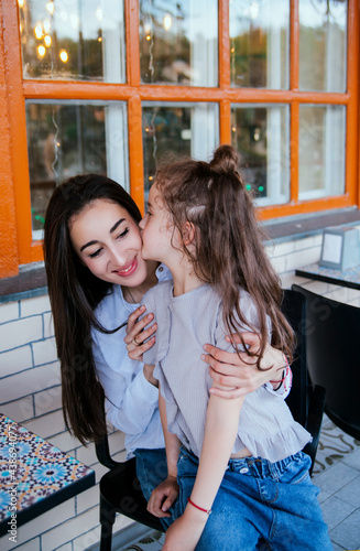 Wallpaper Mural A young mother embraces her little daughter. The girl is sitting in the arms of a woman. Torontodigital.ca