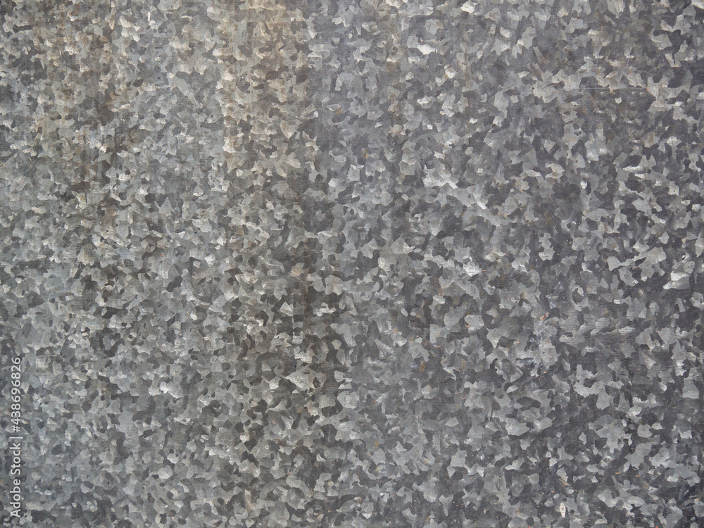 The texture is a sheet of galvanized gray spotted iron in full screen. Metal sheathing. Industrial dirty background close-up. The texture is a sheet of galvanized gray spotted iron in full screen. Metal sheathing. Industrial dirty background close-up.