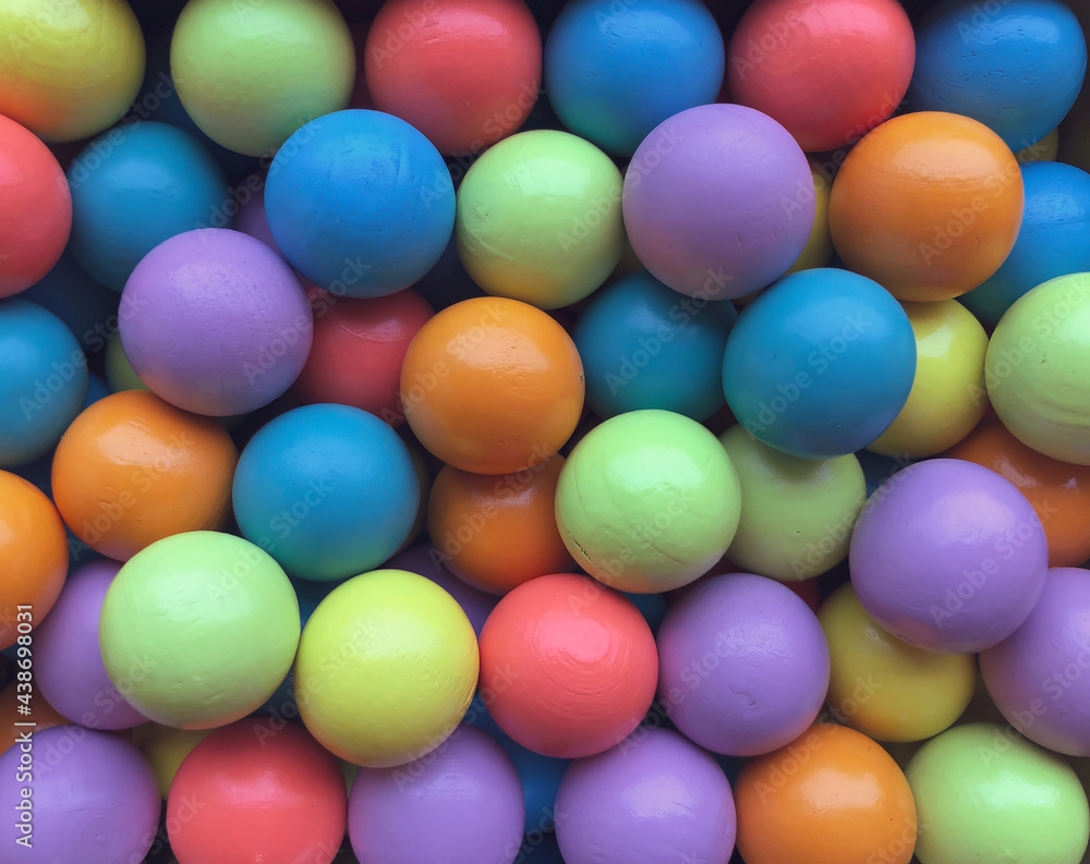 Background from multicolored bright small wooden balls of blue, yellow, red, lilac and green colors. A beautiful summer bright background for your projects. Background from multicolored bright small wooden balls of blue, yellow, red, lilac and green colors. A beautiful summer bright background for your projects.