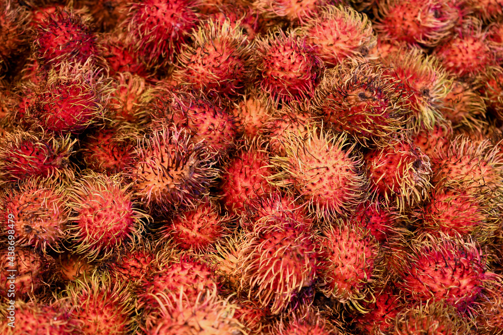 Fresh rambutan with bright red color and spines at the local farmers market Fresh rambutan with bright red color and spines at the local farmers market