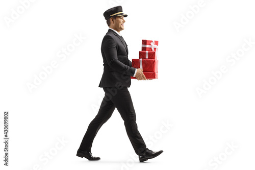 Schilderij op canvas Full length profile shot of a porter carrying a pile of presents