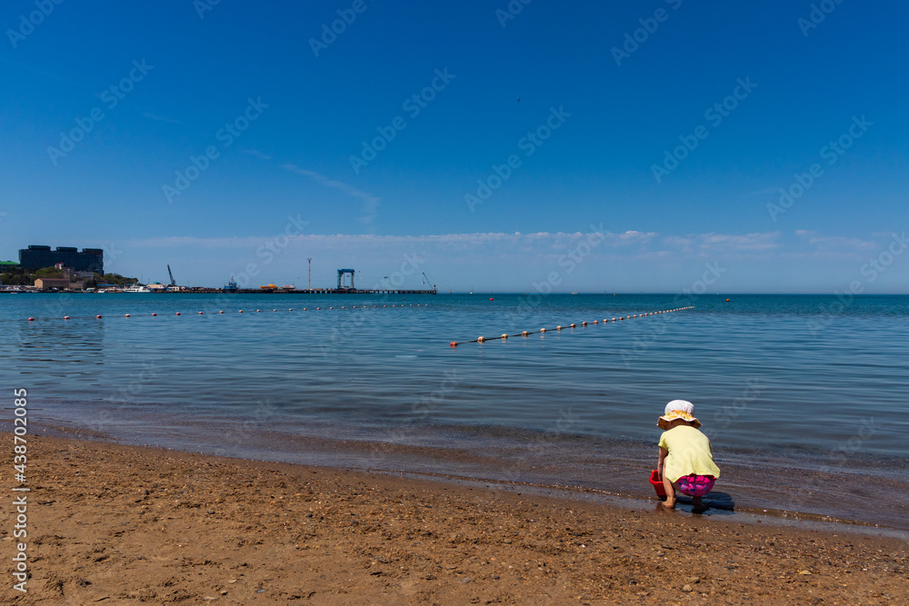 Anapa. Krasnodar Region - May 14, 2021: a child plays on the Black Sea coast Anapa. Krasnodar Region - May 14, 2021: a child plays on the Black Sea coast