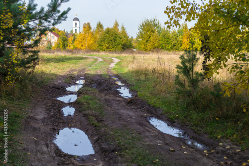 dirty country road among the endless forests and fields after heavy rains	