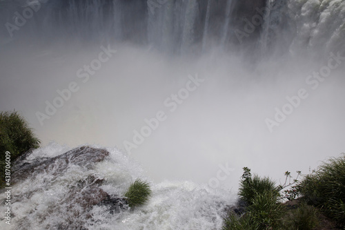 Vertigo. Amazing view of the Iguazú waterfalls seen from the Devil's Throat in Iguazú National Park, in Misiones Argentina. The falling white water, mist and splash.