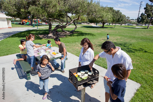 Two families enjoying BBQ in the park
