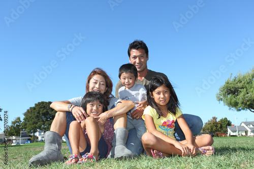 Family portrait looking at the camera on the grass 