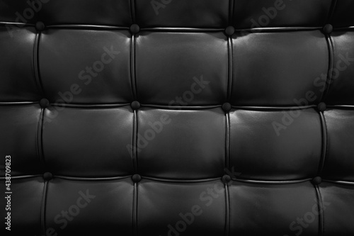 Black leather sofa texture in royal style. Elegant embossed black leather pattern. Vintage style and geometry pattern. Upholstery artificial texture with buttons.