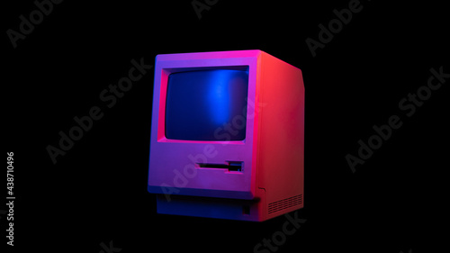 Retro wave 80s computer all-in-one illuminated by neon light isolated on black