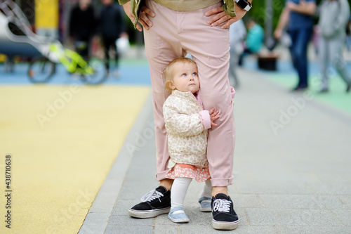 Cute toddler girl having fun on outdoor playground. Young father playing with her little daughter. Spring/summer/autumn active leisure for family with kids.