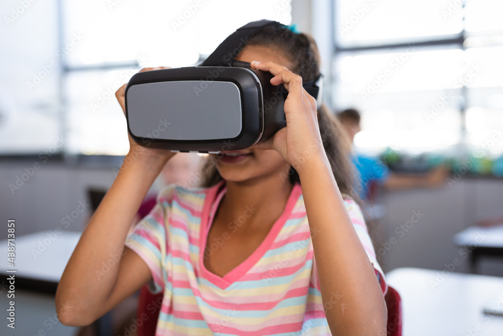 African american girl wearing vr headset while sitting on her desk in the class at school African american girl wearing vr headset while sitting on her desk in the class at school