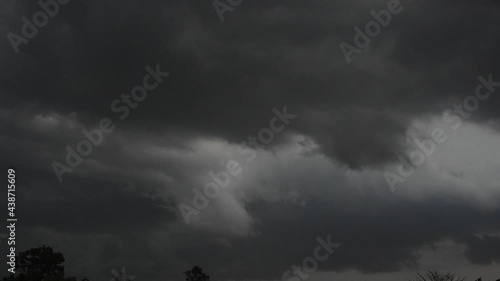 Rainstorm over the country in Thailand. Bad weather with clouded sky, rain. Massed gray clouds flowing over, climate change, tropical storm with bolt.