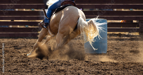Horses and cowboys at the rodeo with fast moving racing and dirt flying.
