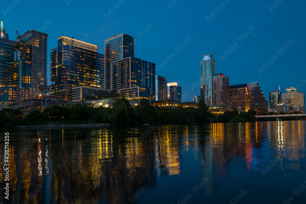 Downtown Skyline of Austin, Texas in USA from view at sunset. Reflection in water.