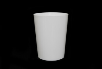 a standing cup from the front point of view. minimal shot for simple mockup. white plastic cup on black background. realistic mockup for promotion.