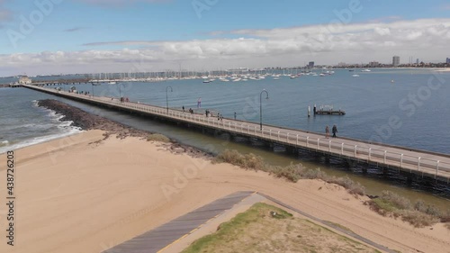 Wallpaper Mural Aerial orbiting shot showing coast of St Kilda Beach in with sandy beach,ocean water and Melbourne Skyline in background during sun Torontodigital.ca