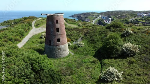 Amlwch port red brick disused abandoned windmill aerial view North Anglesey Wales slow pull back reveal photo