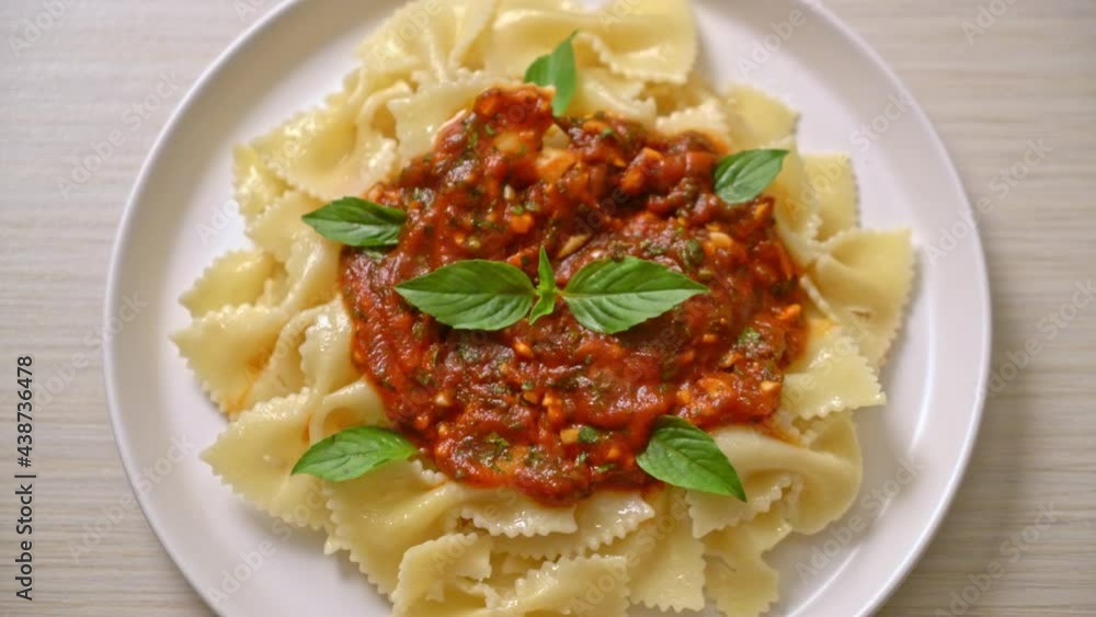 farfalle pasta with basil and garlic in tomato sauce - Italian food style farfalle pasta with basil and garlic in tomato sauce - Italian food style