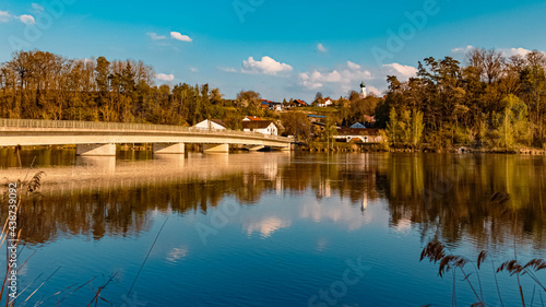 Beautiful spring view with reflections of a bridge and a village at Zeholfing, Isar, Bavaria, Germany