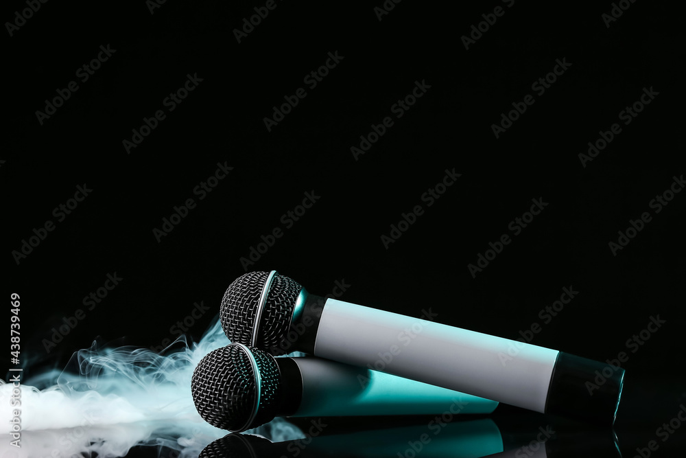 Modern microphones on dark background with fume