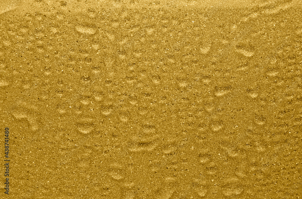 Golden shimmer and glitter wet texture with drops. Rich golden background. Golden shimmer and glitter wet texture with drops. Rich golden background.