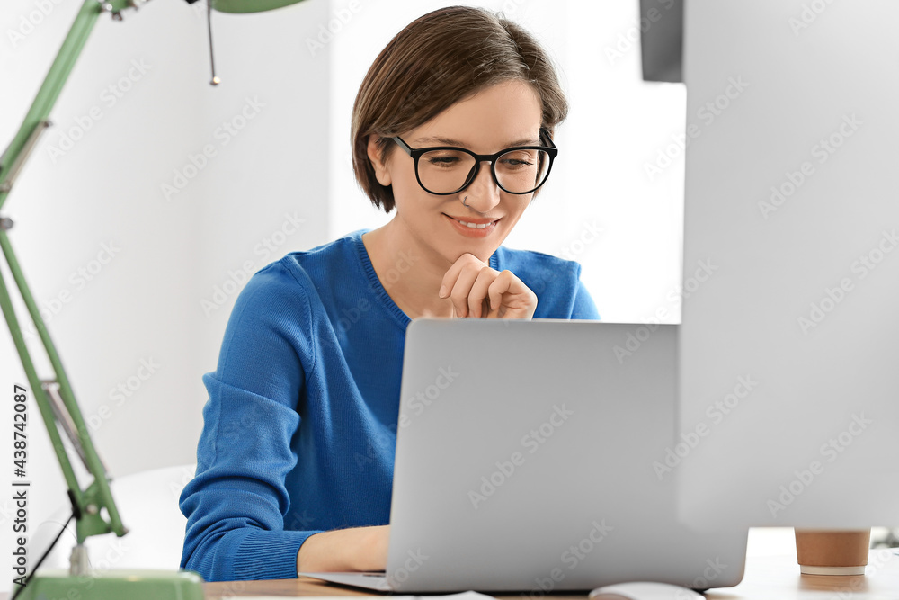 Female programmer working with laptop in office Female programmer working with laptop in office