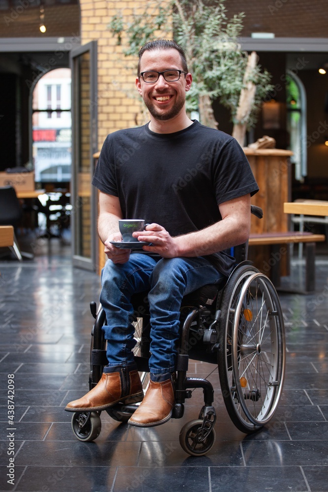 Obraz premium man in wheelchair with a cup of coffee in restaurant