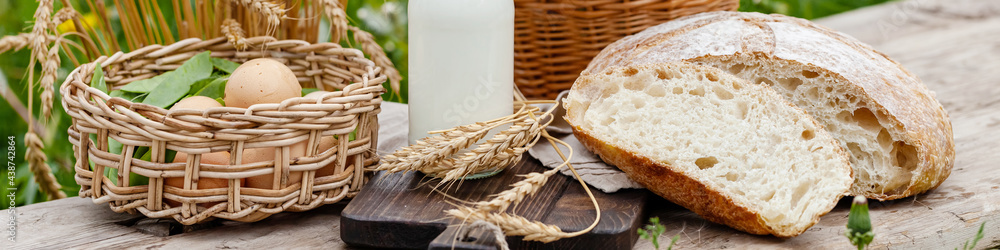 Concept of natural organic products from the local farm. Homemade bread, fresh milk, eggs. Wooden background, outdoors. Close up, copy space for text. Banner Concept of natural organic products from the local farm. Homemade bread, fresh milk, eggs. Wooden background, outdoors. Close up, copy space for text. Banner