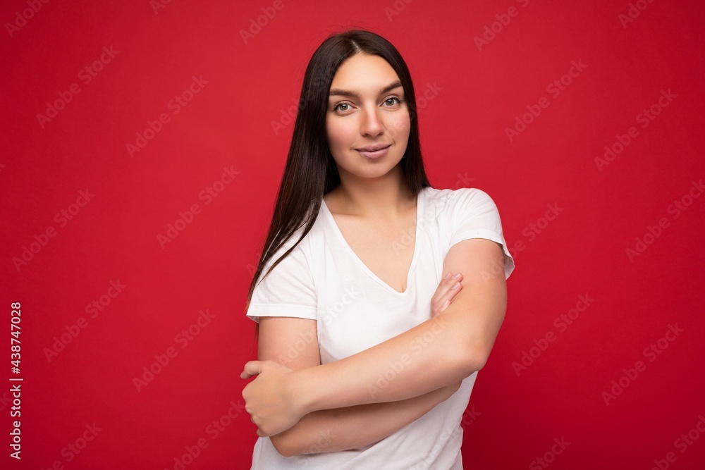 Young beautiful brunette woman with sincere emotions isolated on background wall with copy space wearing stylish white t-shirt for mock up. Positive concept Young beautiful brunette woman with sincere emotions isolated on background wall with copy space wearing stylish white t-shirt for mock up. Positive concept