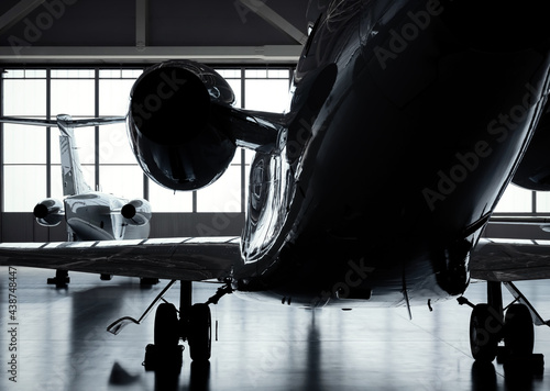 Luxury private jet plane storage inside the hangar. Natural black and white high contrast. 