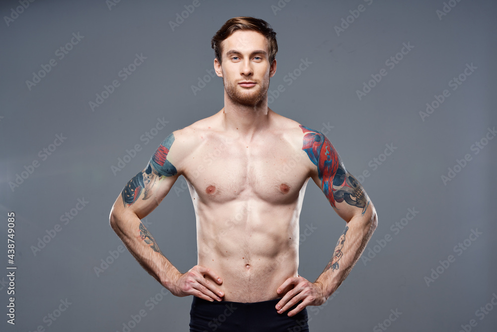 Fototapeta premium athletic man with pumped up abs tattoos on his arms