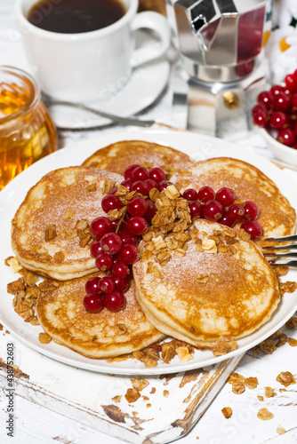delicious pancakes with berries and honey for breakfast, vertical