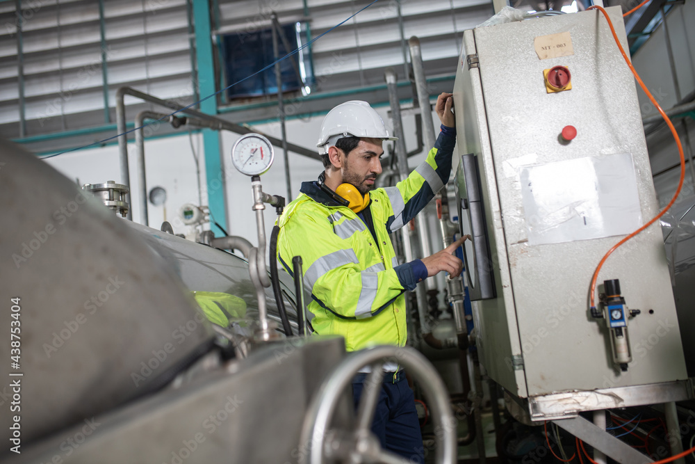 workers inspecting pressure valves on a tank. workers inspecting pressure valves on a tank.