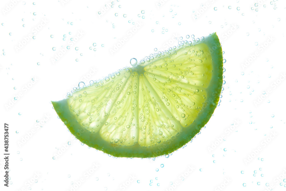 Slice of lime in sparkling water on white background. Citrus soda Stock