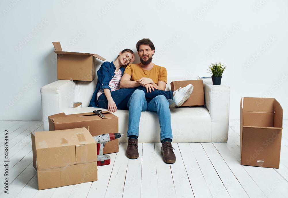 Young family sitting on couch boxes with stuff moving fun Young family sitting on couch boxes with stuff moving fun