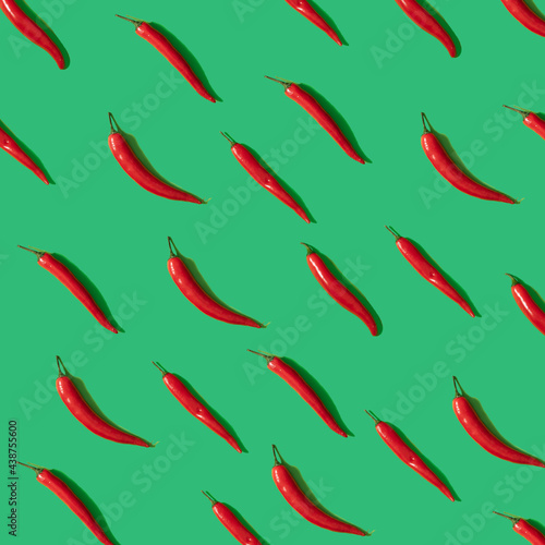 Red chili peperrs on green pastel background, flat lay pattern square composition
