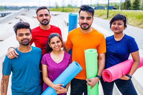 four indian people warming up outdoors in sport wear morning time urban photo