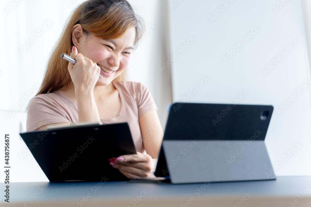 Image of happy asian woman using laptop while sitting at home. Image of happy asian woman using laptop while sitting at home.