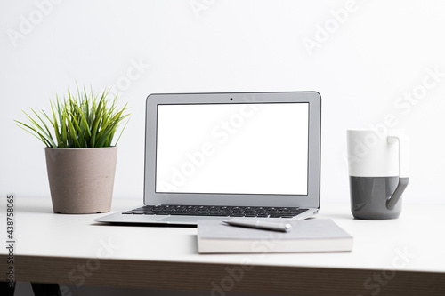 Laptop with blank screen on work table. Home office or work space concept