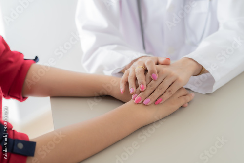 Hand of doctor reassuring her female patient. Asian people