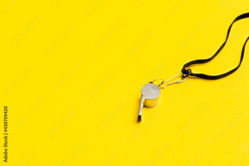 Sports whistle on yellow background. Concept - sport competition, referee, statistics, challenge. Basketball, handball, futsal, volleyball, soccer, baseball, football and hockey referee whistle Sports whistle on yellow background. Concept - sport competition, referee, statistics, challenge. Basketball, handball, futsal, volleyball, soccer, baseball, football and hockey referee whistle