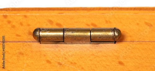 Small door hinge of gold color on a wooden box photo