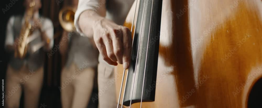 CU Caucasian male playing double bass during jazz band rehearsal or concert. Shot with 2x anamorphic lens CU Caucasian male playing double bass during jazz band rehearsal or concert. Shot with 2x anamorphic lens