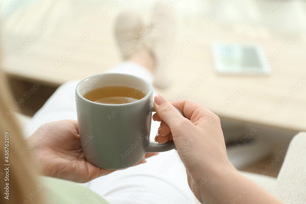 Young woman with cup of hot tea relaxing at home, closeup Young woman with cup of hot tea relaxing at home, closeup