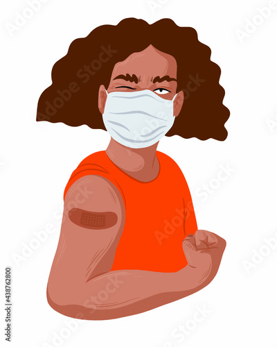 A person wearing a mask and showing off their vaccination band-aid.	